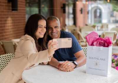 Man and woman sitting at a table taking a photo of themselves