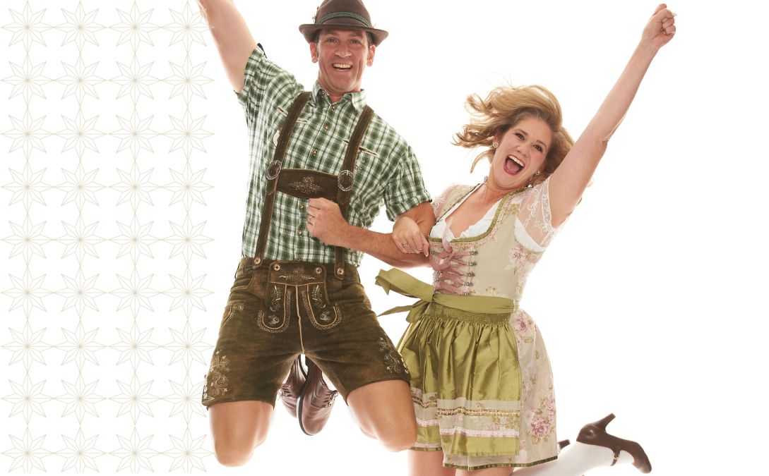 Man and woman dressed up in traditional lederhosen attire.